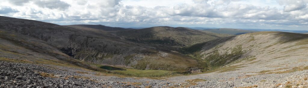 Paratiisikuru ja sen pohjalla oleva lampi usean kivisen tunturinrinteen välissä
